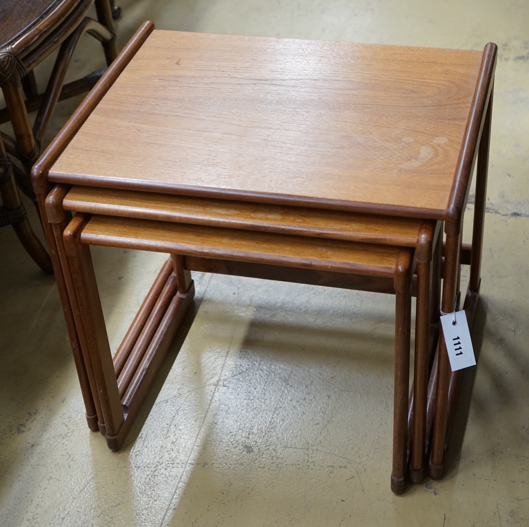 A mid century design nest of three rectangular teak tea tables, width 54cm, depth 43cm, height 48cm